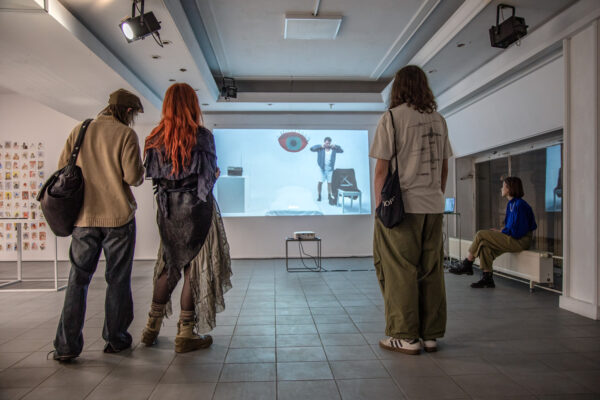 four people watching a projection screened on a wall