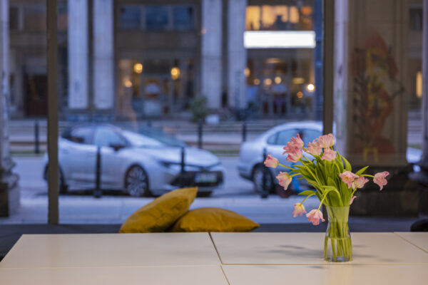 przestrzeń WOK Lab, bukiet różowych tulipanów stojący na stole, w tle okno z widokiem na ulicę Marszałkowską