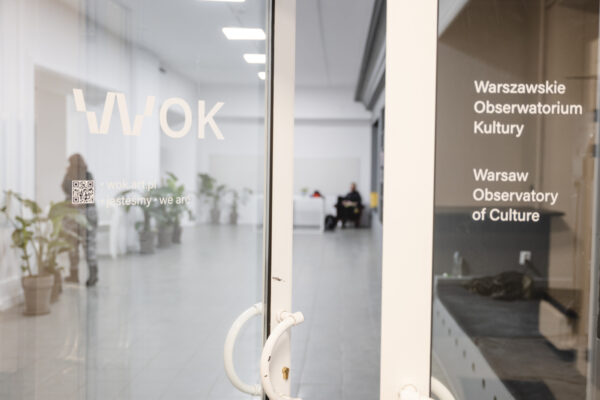 uchylone główne drzwi do WOK Lab, zachęcające do wejścia, na drzwiach widoczna nazwa i logo